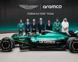 El equipo Aston Martin Aramco Cognizant Formula One Team posa junto a su coche verde brillante.
