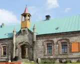 Kamienne schronisko orle z turkusowym dachem i wieżyczką.