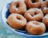 Rosquillas caseras de toda la vida, doradas y espolvoreadas con azúcar, listas para disfrutar.