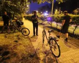 Policjant rozmawia z rowerzystą, który może stracić prawo jazdy. Nocna interwencja na ścieżce rowerowej.