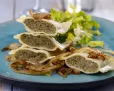 Gestapelte Maultaschen mit gebratenen Zwiebeln und Salat. Ein köstliches Maultaschen Rezept, das Appetit macht.