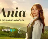 Ania z Zielonego Wzgórza, rudowłosa dziewczynka z piegami, patrzy zza zielonych wzgórz.