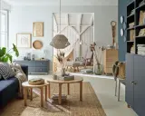 Przytulny salon z granatową sofą, drewnianymi stolikami i dekoracjami na ścianę. Idealne miejsce na relaks.