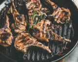Saftige Lammkoteletts mit Grillstreifen in einer Pfanne, garniert mit Rosmarin. Perfekt zum Lamm grillen!