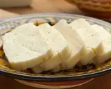 Pokrojony w plastry domowy ser halloumi na ozdobnym talerzu.