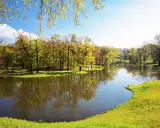 Malowniczy park z jeziorem i drzewami w wiosennej odsłonie. Idealne miejsce na spacer i podziwianie łęknica atrakcje.