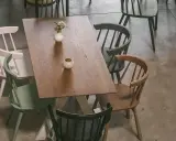 Holztisch mit bunten Stühlen und Deko-Elementen, aus der Vogelperspektive.