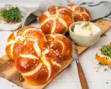 Frisch gebackene laugen knoten mit Sesam und grobem Salz, dazu Butter und Kresse.