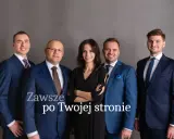 Pięć osób w garniturach stoi na szarym tle. Napis "Zawsze po Twojej stronie".