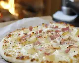 Flamenkuche, une tarte fine garnie de lardons et de crème, évoque son origine alsacienne.
