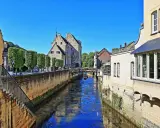 Idyllischer Kanal in der Valkenburg Altstadt, gesäumt von historischen Gebäuden und Bäumen.