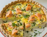 Une délicieuse quiche sans pâte grand-mère au saumon, oignons et persil, coupée en part.