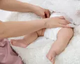 Mani di madre cambiano il pannolino al neonato, un gesto d'amore per prevenire e curare dermatite da pannolino.