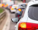 Un coche blanco en un atasco, con sus luces de freno rojas encendidas. ¿Cuántas luces de freno tiene un coche?