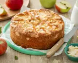 Un délicieux clafoutis aux pommes, parsemé d'amandes effilées, prêt à être dégusté. Une recette inspirée du carnet de Julie.