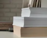 Stosy białego i beżowego papieru, gotowe do druku. Ten papier powlekany czeka na kreatywne projekty.