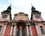 Święta Lipka: barokowa bazylika z zegarami na wieżach i złotymi symbolami religijnymi. Atrakcje tego miejsca przyciągają turystów.