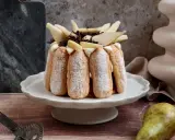Charlotte poire chocolat, un dessert élégant avec des biscuits à la cuillère, garni de poires fraîches et de copeaux de chocolat.