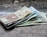 Zbiór polskich banknotów, od 10 do 50 zł, leżących na marmurowym blacie. Warto wiedzieć, jak odzyskać zaległe alimenty, gdy pieniądze są tak potrzebne.