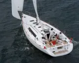 Un voilier Oceanis 34 navigue sur une mer agitée. Les avis sur ce bateau sont positifs, il offre une belle expérience de navigation.