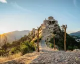 Petralia Soprana: cosa vedere in questo borgo arroccato, con un sentiero in pietra che sale verso il castello al tramonto.