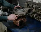 Mechanik sprawdza turbosprężarkę, przygotowując się do jej montażu.