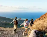 Vandrare njuter av utsikten över havet och landskapet på Santorini. En man pekar ut mot horisonten.