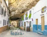 Calle bajo roca en Setenil de las Bodegas, uno de los pueblos mas bonitos de Andalucia. Casas blancas con balcones floridos y barriles de vino.