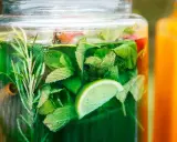 Zielony, orzeźwiający syrop z mięty z dodatkiem limonki i rozmarynu, gotowy do schłodzenia.