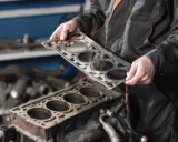Mecánico sosteniendo una junta de culata nueva para el mantenimiento del motor.