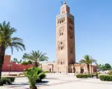 Koutoubia-Moschee in Marrakesch, ein Wahrzeichen und ein Muss für Marrakesch Geheimtipps. Palmen säumen den Platz.