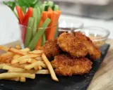 Krispiga chicken nuggets med pommes frites och grönsaksstavar. Perfekt för en mysig kväll!