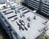 Widok z lotu ptaka na płaski dach nowoczesnego budynku mieszkalnego z systemami wentylacyjnymi i klimatyzacyjnymi. To idealne miejsce na wyjście na dach i podziwianie panoramy.