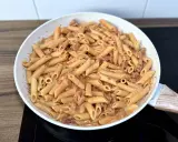 Penne z kremowym sosem i kawałkami pikantnego chorizo, gotowe do podania.
