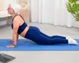 Donne di 50 anni in forma, praticano yoga a casa seguendo un tutorial online.