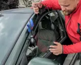Mężczyzna używa pompki i narzędzia do otwierania drzwi, gdy zatrzasnął kluczyki w samochodzie. Jak otworzyć auto bez kluczyka?