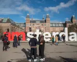 Ludzie pozują przy wielkich literach "I amsterdam" przed Rijksmuseum. Idealne miejsce na pamiątkowe zdjęcie z weekendu w Amsterdamie.