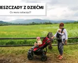 Kobieta z dzieckiem w chuście i dziewczynka w wózku na tle malowniczych Bieszczad.