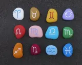 Kolorowe kamienie z symbolami zodiaku ułożone w rzędach. Sprawdź dopasowanie znaków zodiaku!