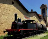 Locomotora antigua frente a las bodegas de Haro, transportando barriles de vino.