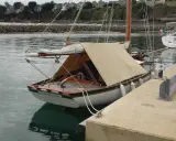 Un cotre de Carantec, "Le Vieux Gui", est amarré au port. Une autre voile blanche est visible à côté.