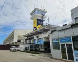 Kontrolltorn och terminalbyggnad vid Zanzibar flygplats. En vit SUV parkerad framför.