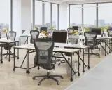 Bureau moderne avec postes de travail alignés, illustrant l'avantage open space pour la collaboration et la flexibilité.
