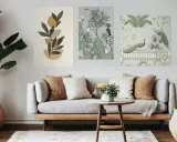 Trois cadres sont disposés sur un mur : un abstrait végétal, un jardin avec des oiseaux, et un autre avec des paons.