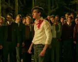 En ung man med blodstänk på sin vita skjorta står omgiven av andra unga män i skoluniformer. Scenen är från tv-serien "rollistan i ondskan".