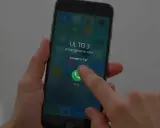 Dłoń naciska przycisk "Emergency Call" na ekranie telefonu, pokazując, jak odblokować telefon przez połączenie alarmowe.