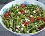 Salade estivale de haricots verts, tomates cerises, poivrons jaunes et feta. Un délice frais et coloré.