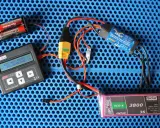 Jeti Box mit ESC-65-Menü, ibex 65 HV ESC, Hacker LiPo-Akku und Batterien auf blauem Untergrund.