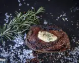 Perfekt medium gegrilltes Steak mit Kräuterbutter, Rosmarin und grobem Salz.