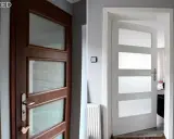 Przed i po: renowacja drzwi drewnianych. Ciemne drewno zamienione na jasną biel, nadając wnętrzu lekkości i nowoczesności.